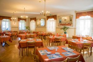 a dining room with red tables and chairs at Waldhotel Unspunnen in Interlaken
