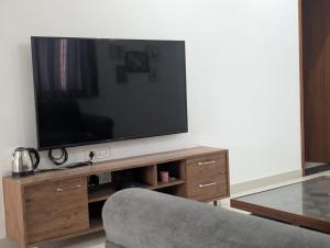 a flat screen tv sitting on top of a wooden entertainment center at Karmawas House in Jodhpur