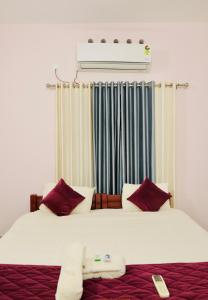 a bedroom with a large bed with red pillows at Varkala Escape Resort in Varkala