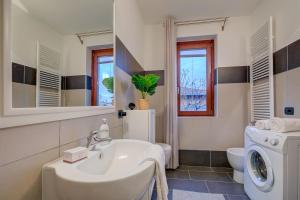 a bathroom with a sink and a washing machine at Lenni Apart. Swimming Pool and lake + WIFI - Happy Rentals in Leggiuno