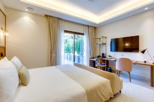 a hotel room with a large bed and a desk at The Manor - New Delhi in New Delhi