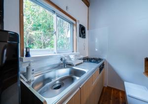 a kitchen with a sink and a window at simAsim Cottage Kouri in Nakijin +27 photos