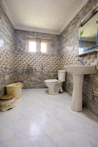 a bathroom with a sink and a toilet and a sink at Lidder view resort in Muski