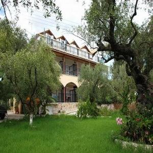 a large house in a yard with trees and grass at Dakis Studios in Keri