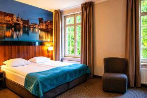 a hotel room with a bed and a chair at Apart Neptun in Gdańsk +75 photos