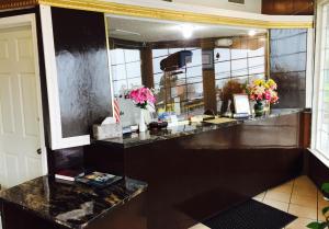 a lobby with a counter with flowers on it at Maple Inn and Suites Los Banos in Los Banos