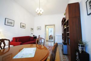 salon ze stołem i czerwoną kanapą w obiekcie Casa Anna a Roma w Rzymie