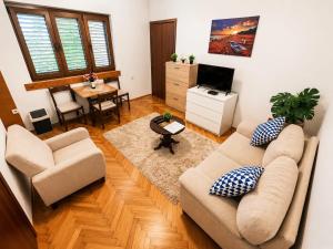 a living room with two couches and a television at Apartman Jadran Private Parking in Dobrota