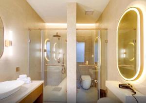 a bathroom with a shower and a sink and a toilet at The Manor - New Delhi in New Delhi +201 photos