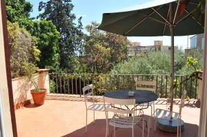 patio con tavolo, sedie e ombrellone di Tibidabo Apartments a Barcellona