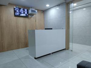 a room with a white partition with a tv on a wall at Hotel Captown Inn in Ahmedabad