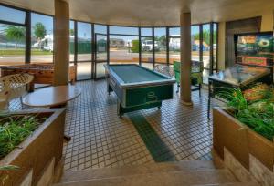 a lobby with a pool table and tables and windows at Camping Playa la Arena in Isla