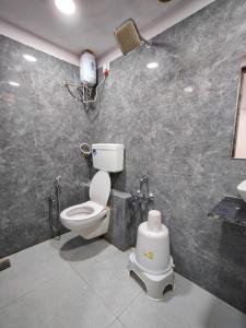 a bathroom with a toilet and a shower and a sink at Hotel Captown Inn in Ahmedabad