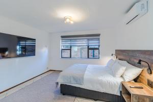 a bedroom with a bed and a wooden table at Urban Escapes - LINDEN COTTAGE in Johannesburg