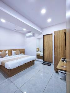 a bedroom with a bed and a desk at Hotel Captown Inn in Ahmedabad