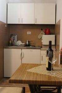 a kitchen with a table with a bottle of wine at Apartman Jadran Private Parking in Dobrota