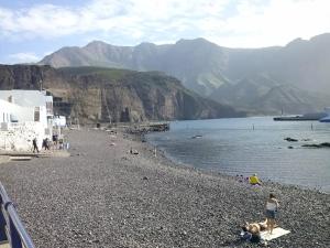 a group of people on a beach near the water at Casa Lola in Agaete