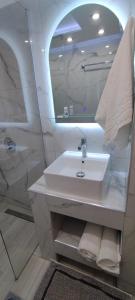 a bathroom with a white sink and a mirror at Sweetmar guest Rooms-ground floor in Kos