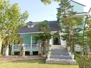a home with a blue house with a porch at Charisma Resort in Suan Phung