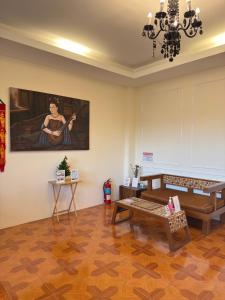 a living room with a couch and a painting on the wall at inghome & guesthouse in Chiang Mai