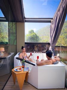 a man and woman sitting in a bath tub in a room at The Blackberry Retreat Kandy in Kandy