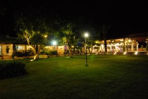 a park lit up at night with trees and lights at Il Vigneto Resort in Menfi
