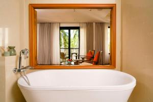 a bath tub in a bathroom with a large mirror at Tanjung Rhu Resort in Tanjung Rhu +120 photos