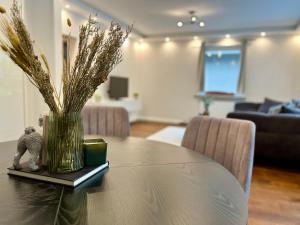 a dining room table with a vase of flowers on it at Modernes Designer-Apartment in ruhiger Lage in Soltau