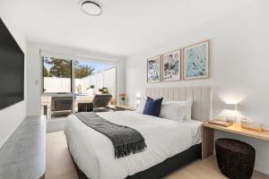 a bedroom with a bed and a living room at Casa Bianca - Fireplace with Swimming Pool in Callala Beach +42 photos