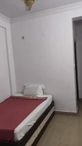 a bed in a room with a white wall at HOTEL BPR Residency in Hyderabad