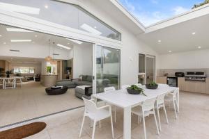 a living room with a white table and chairs at Casa Bianca - Fireplace with Swimming Pool in Callala Beach