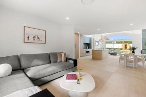 a living room with a couch and a table at Casa Bianca - Fireplace with Swimming Pool in Callala Beach