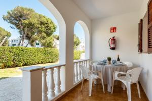 a dining room with a table and chairs and a window at Apartamentos Mar Blanca by Mauter Villas in Cala Blanca