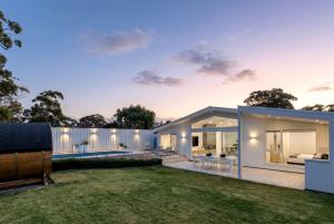 a contemporary home with a white fence and a yard at Casa Bianca - Fireplace with Swimming Pool in Callala Beach