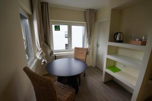 a small room with a table and chairs and a window at Pension Dortmund Messe in Dortmund