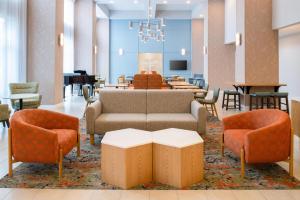 a lobby with a couch and chairs and a piano at Hampton Inn & Suites Redding in Redding