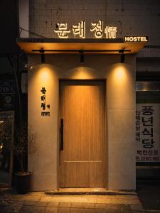 a wooden door on the side of a building at Moonraejung Hostel in Seoul