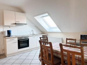 a kitchen with a table and a stove and a window at Lindenhof Helmke in Schellerten