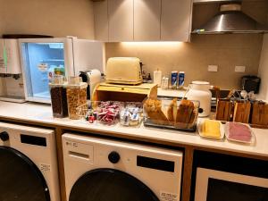 a kitchen with washing machines and food on a counter at Moonraejung Hostel in Seoul