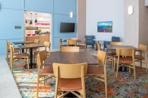 a dining room with tables and chairs and a tv at Hampton Inn & Suites Redding in Redding