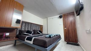 a bedroom with a large bed with a wooden headboard at Nirvana Homestay in Mathura