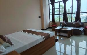 a bedroom with a bed and a couch and a table at Marigold in Kalimpong +10 photos