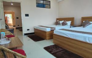 a hotel room with two beds and a table at Marigold in Kalimpong