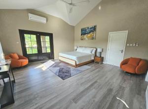 a bedroom with a bed and two orange chairs at Golden Pear Villa-CR in Confer +21 photos