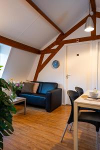 a living room with a blue couch and a table at Short Stay Wageningen in Wageningen