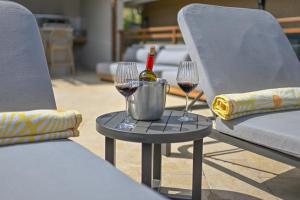 two wine glasses and a bottle of wine on a table at Golden Pear Villa-CR in Confer