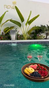 a tray of fruit and wine glasses in a swimming pool at Rove Chalet in á¸¨arÄdÄ«