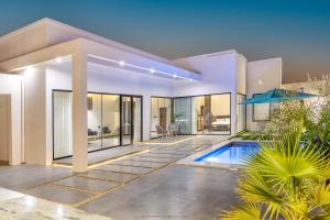 a villa with a swimming pool and a house at Rove Chalet in á¸¨arÄdÄ«