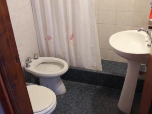 un baño con inodoro y lavabo en Hotel Demi, en Villa Gesell