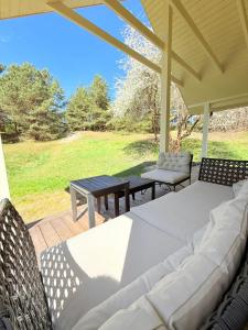 a porch with two beds and a picnic table at Papės Perlas in Pape +117 photos